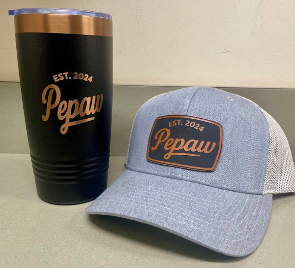 Black tumbler and blue cap with 'Pepaw' and 'EST. 2024' text on a neutral background